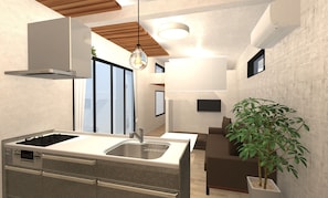 Una cocina moderna con estufa integrada, fregadero y zona de comedor con sofá y planta en maceta.
