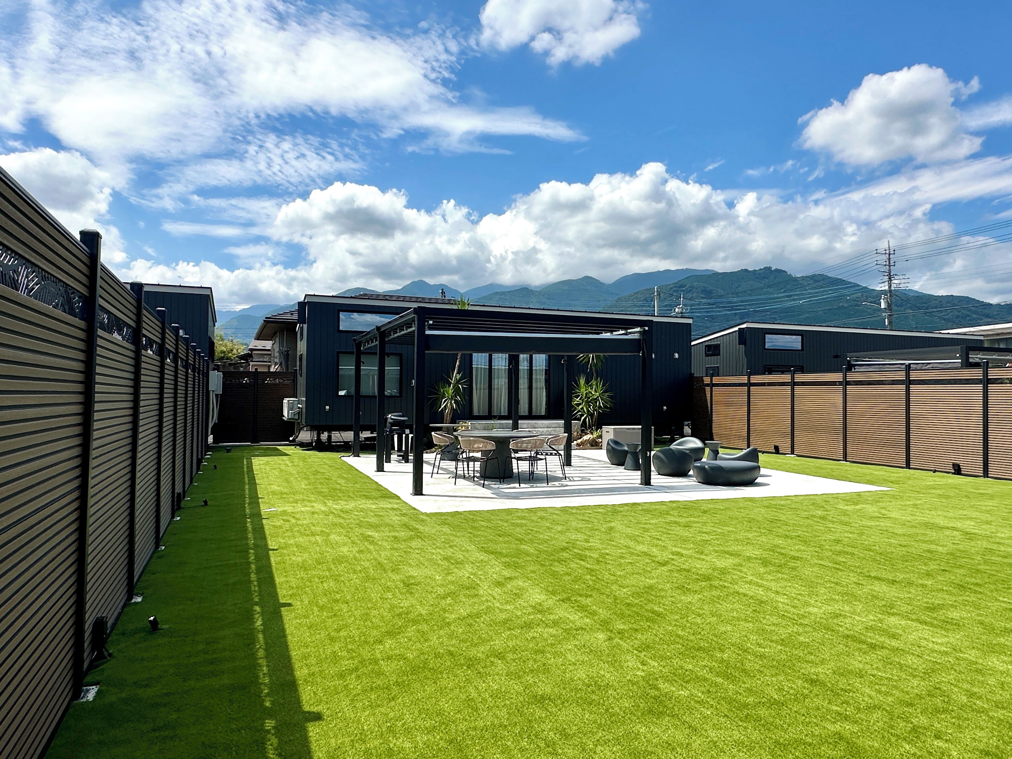 A modern outdoor patio with a dining area, seating, and a view of mountains.