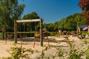 Un parque infantil con columpios, toboganes y estructuras para escalar.
