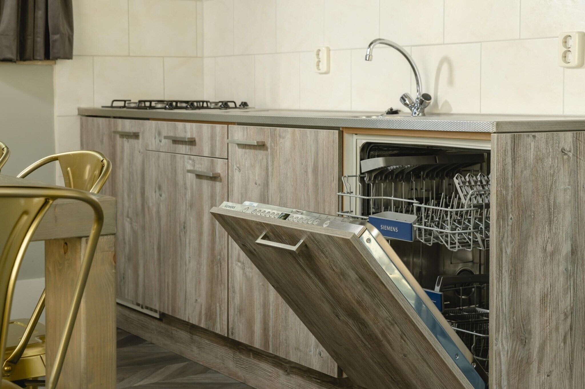 A kitchen with wooden cabinets, a dishwasher, and a sink.