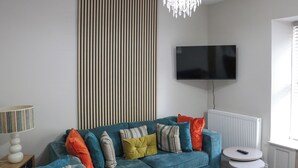 A living room with a sofa, a television, a lamp, and a radiator. - Platform 2 - UK51996 (Haverfordwest)