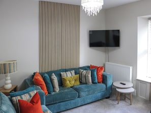 A living room with a sofa, a television, a lamp, and a radiator. - Platform 2 - UK51996 (Haverfordwest)
