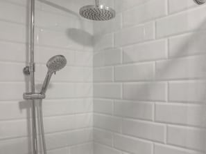 A shower with a handheld showerhead and a wall-mounted rain showerhead in a tiled bathroom. - Platform 2 - UK51996 (Haverfordwest)
