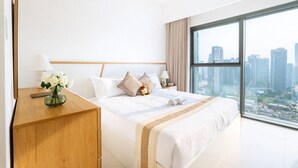 Een moderne hotelkamer met een groot bed, een houten nachtkastje, een vaas met witte bloemen en uitzicht op de stad.