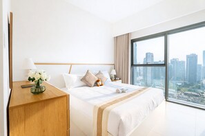 Ein modernes Hotelzimmer mit einem großen Bett, einem Nachttisch aus Holz, einer Vase mit weißen Blumen und Blick auf die Stadt.