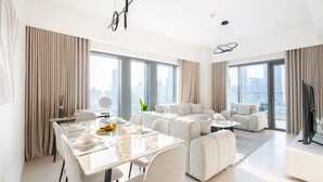 Een moderne woonkamer met een eetgedeelte, grote ramen en uitzicht over de stad.