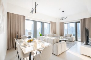 Ein modernes Wohnzimmer mit Essbereich, großen Fenstern und Blick auf die Stadt.