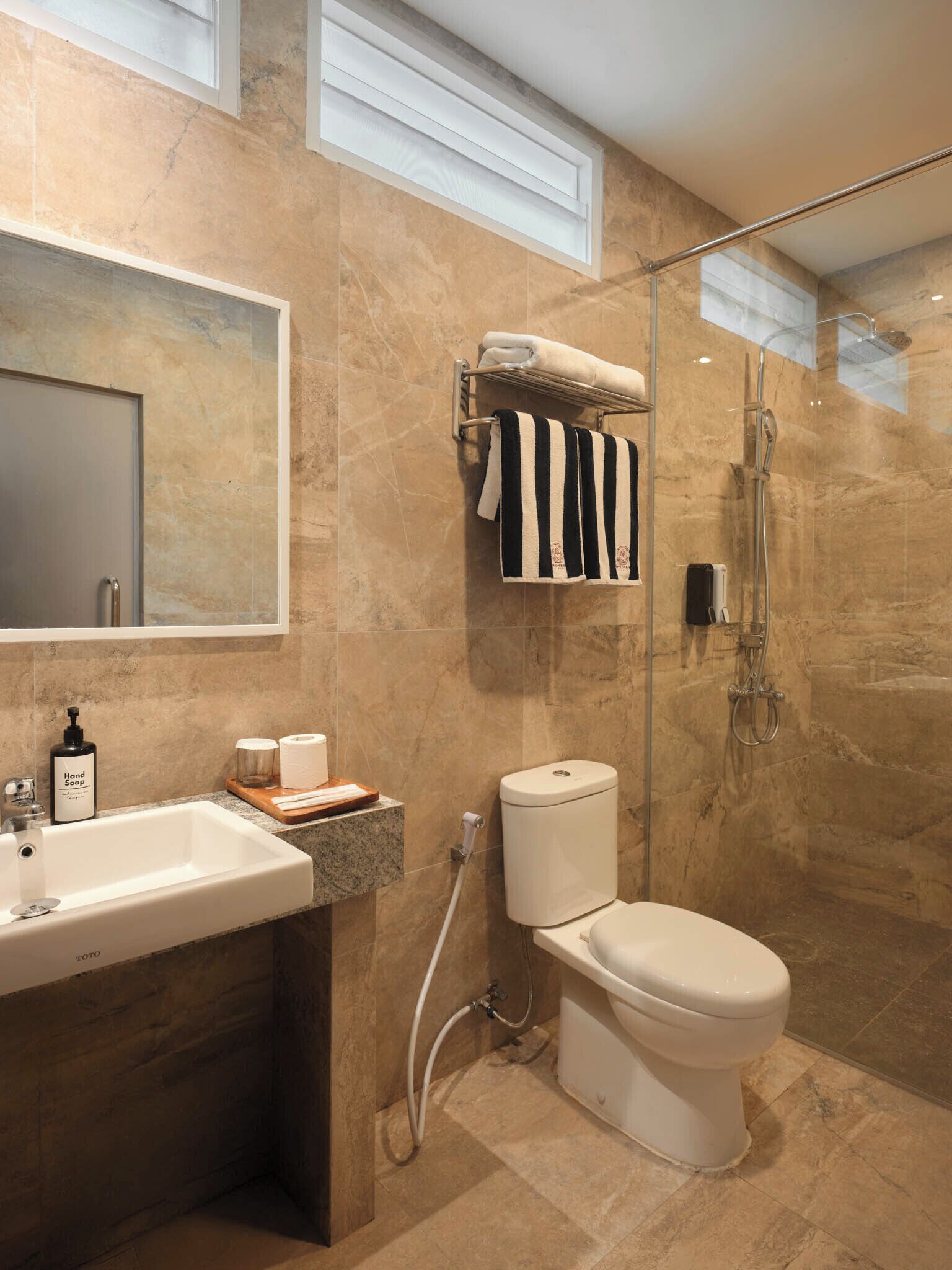 A modern bathroom with a sink, toilet, and shower.