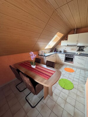 A kitchen with a dining area, a skylight, and a tiled floor. - Quiet designer apartment with whirlpool tub, steam shower, and nature (Lautersheim)