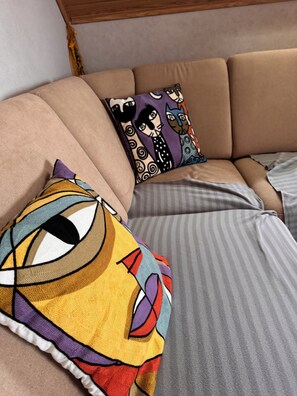 Un sofá con cojines a rayas y dos almohadones decorativos.