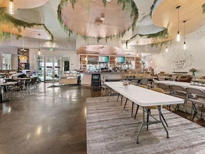 A spacious cafe with a bar area, tables, and chairs arranged for dining and socializing. - Spacious 3-bedroom apartment in gorgeous Destin with AC (Destin)