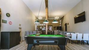 A pool table with three lights, a clock, and a TV on the wall. - Annie's Cottage 2Ch fully equipped house (Ribérac)