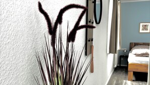 A modern room with a bed, a potted plant, and a wall-mounted artwork. - Studio no. 3 newly furnished modern vacation in Wöhrden near Büsum (Wöhrden)