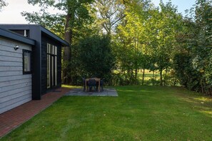 Een modern huis met een terras en een gazon.