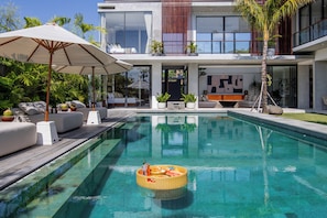 Una piscina al aire libre, sombrillas, tumbonas