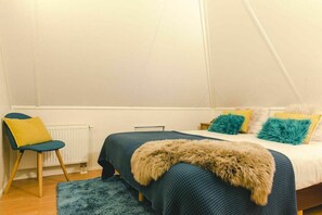 A bedroom with a bed, a chair, a radiator, and a window. - Wellness Lodge for 5 in Zuna (Zuna)