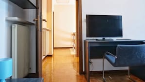 Une chambre moderne équipée d’un téléviseur à écran plat, d’un fauteuil et d’un radiateur.