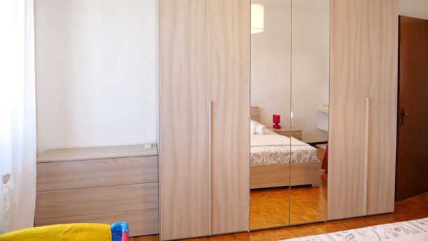 Une chambre avec un placard, un lit et un appareil de climatisation.