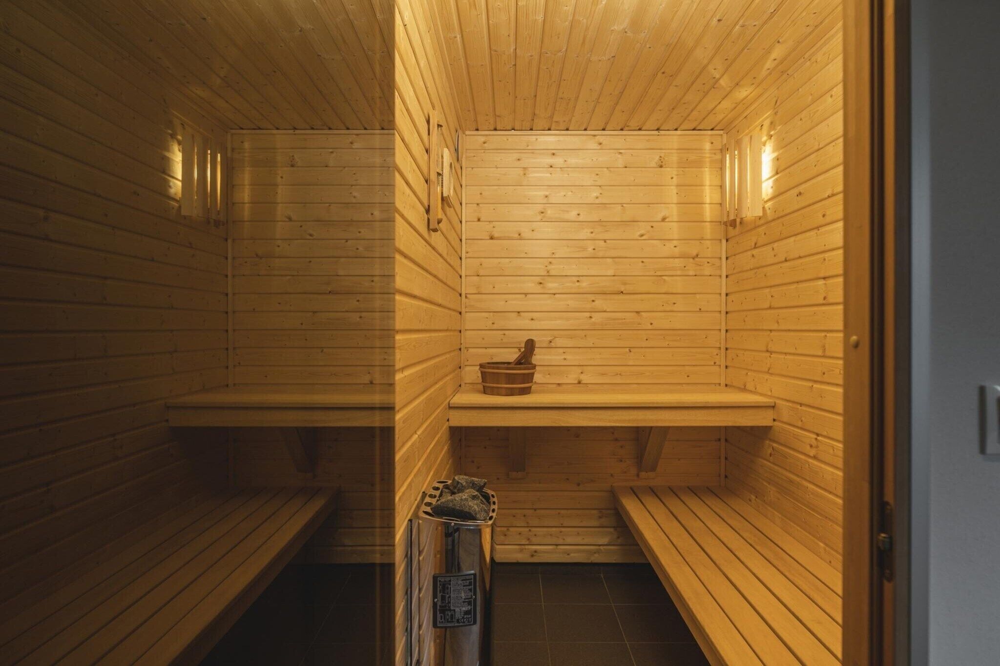 Eine Sauna mit Holzbänken und einem kleinen Holztisch.