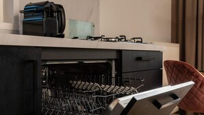 A kitchen with a dishwasher, a coffee maker, and a gas stove. - Cottage with Scenic Pasture Outlook (Zuna)