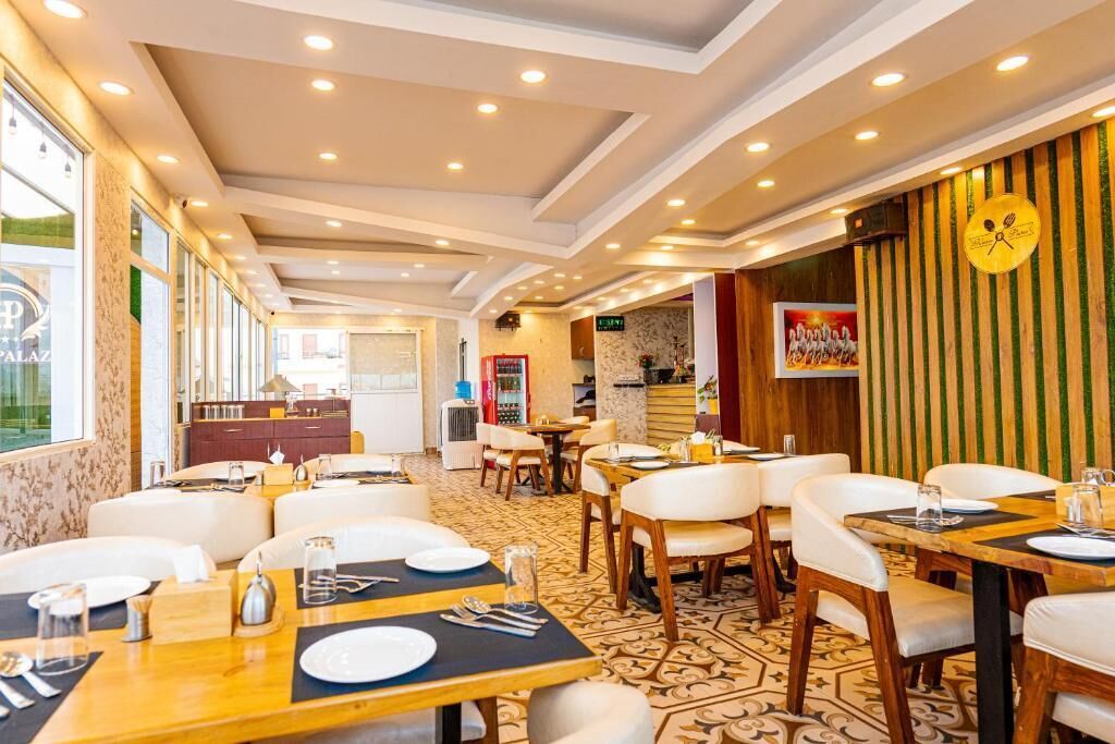 A restaurant with multiple dining tables and chairs, a patterned floor, and a clock on the wall.