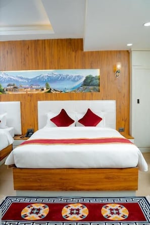 Ein Hotelzimmer mit einem groĂen Bett, einem Holzkopfteil, einem Bild an der Wand und einem gemusterten Teppich.