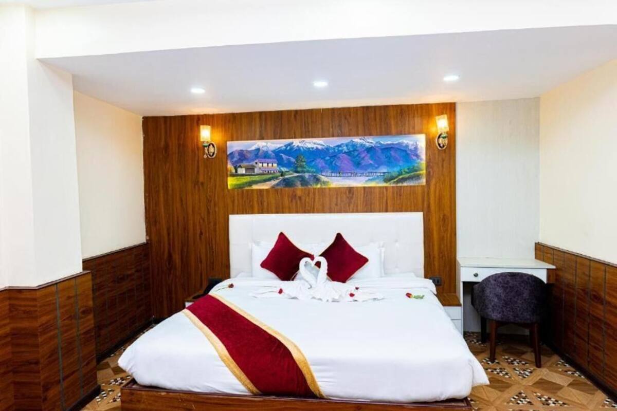 A hotel room with a bed, a desk, and a chair.