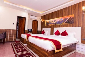 Una cama doble con almohadas rojas, cabecera de madera, un cuadro en la pared y una mesita de noche.