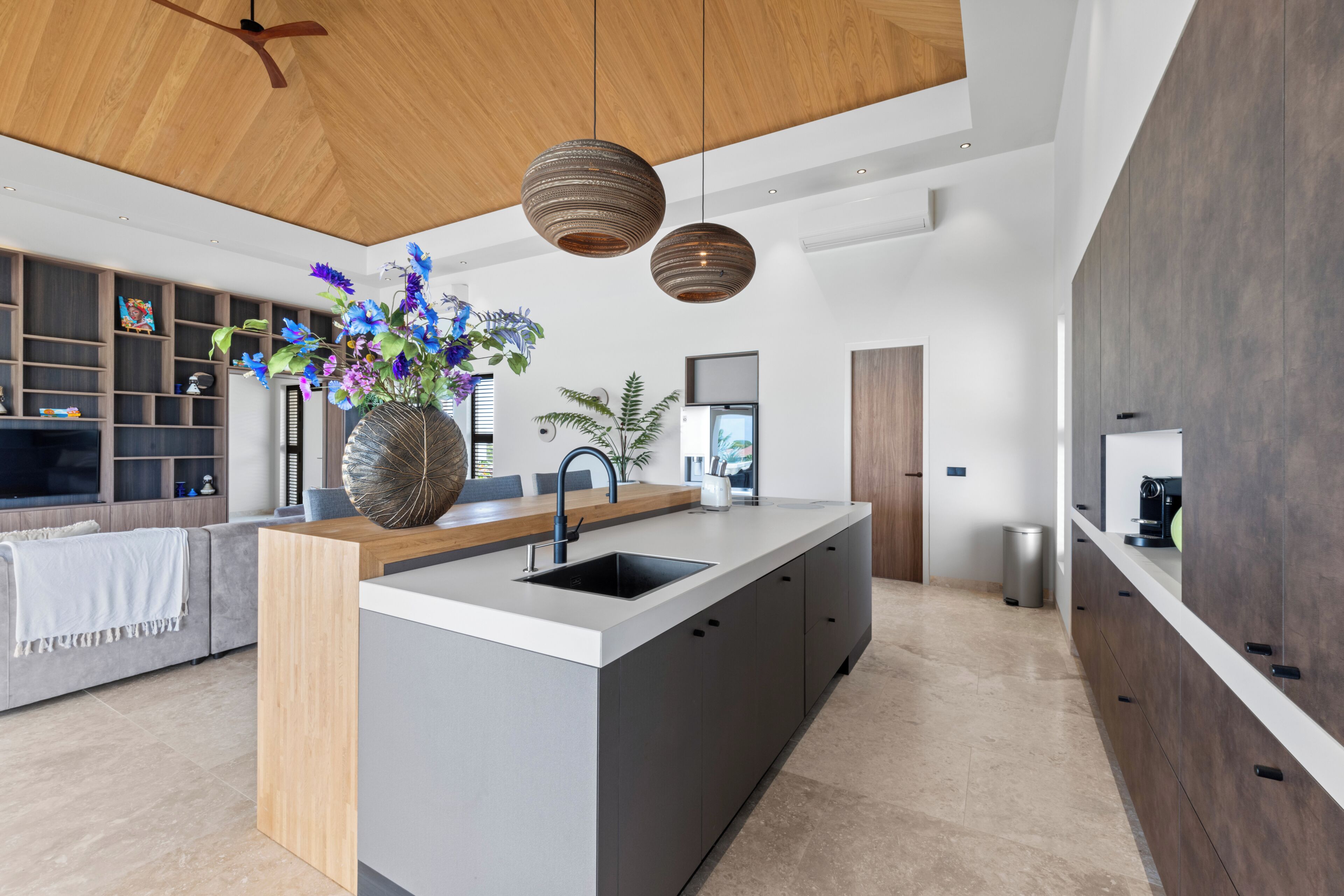 A modern kitchen with a central island, built-in cabinetry, and pendant lighting.