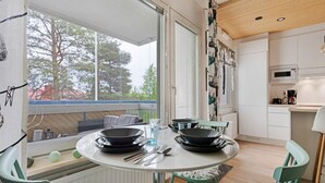 Una cocina moderna con una mesa de comedor, sillas y vistas a árboles.