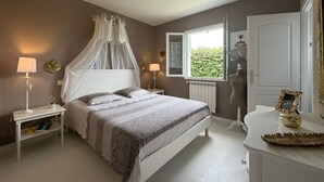 A bedroom with a bed, bedside tables, a window, and a door. - La Villa Ametza - Swimming pool (MOUGUERRE)