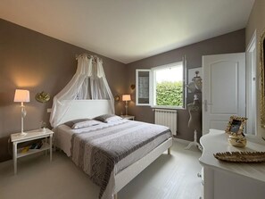 A bedroom with a bed, bedside tables, a window, and a door. - La Villa Ametza - Swimming pool (MOUGUERRE)