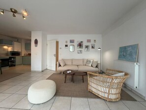 A modern living room with a sofa, ottoman, wicker chair, and a coffee table. - L'Escale de Brindos - Collective pool (ANGLET)