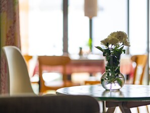 A round table with a clear glass vase containing white flowers. - Komfortable Ferienwohnung in El Turman mit Garten, Terrasse by Interhome (Agaete)