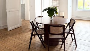 Een eetgedeelte met een ronde tafel, vier stoelen en een potplant.