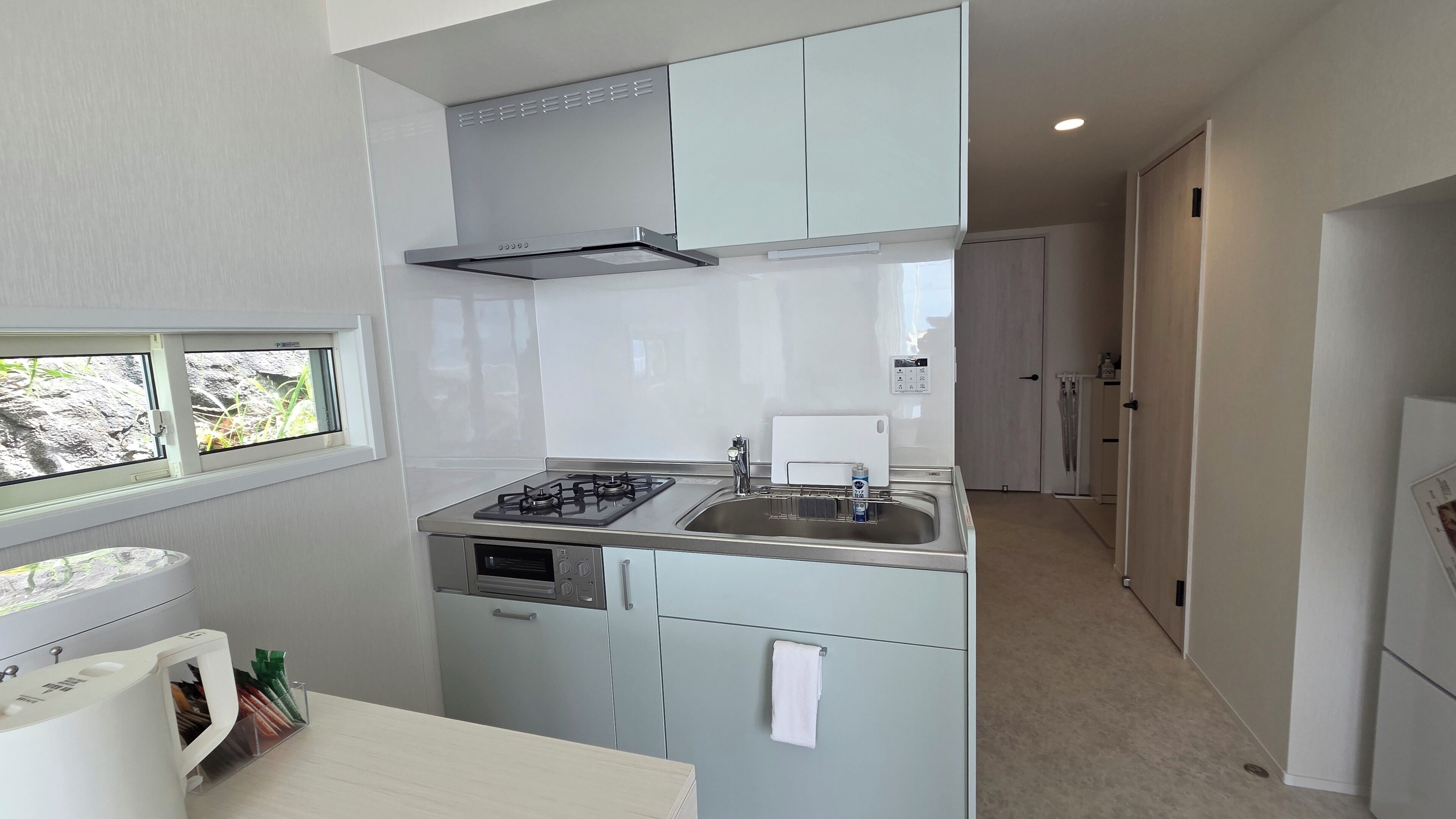 A compact kitchen with a gas stove, sink, and a window.