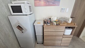 A compact kitchenette with a microwave, refrigerator, and a small coffee machine on a wooden counter. - Solana Beach Villa Minamiboso (Minamiboso)