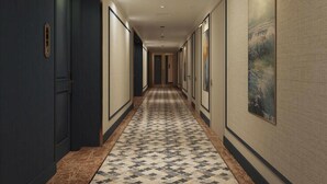 A hotel hallway with a patterned floor, doors on both sides, and framed artwork on the walls. - Centara Hotel & Residences Van Don (Van Don)
