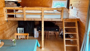 A compact cabin with a bunk bed, a small table with a vase, and a window with a view. - Tinyhouse idyll: nature & chickens (Aurich)