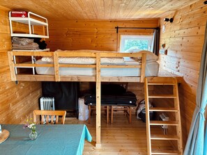 A compact cabin with a bunk bed, a small table with a vase, and a window with a view. - Tinyhouse idyll: nature & chickens (Aurich)