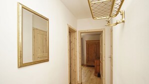 Ein Korridor mit einem großen Spiegel, Holztüren und einem Holzschrank.