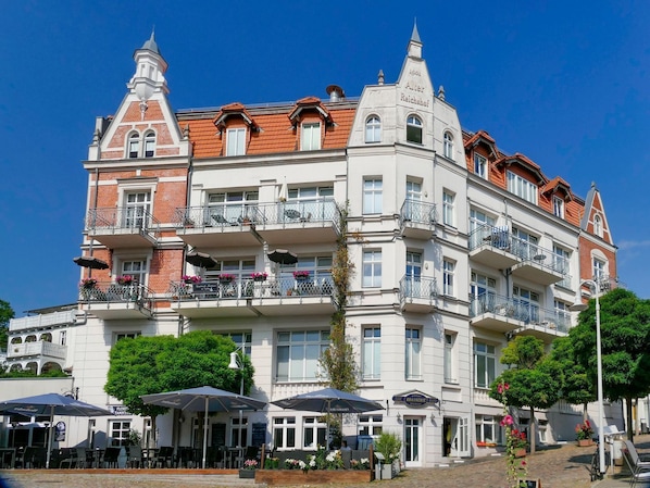 A multi-story hotel with balconies, outdoor seating, and a classic European architectural style. - Alter Reichshof, App. 302 - with balcony and sea view - Alter Reichshof, App. 302 (Sassnitz auf Rügen)