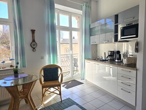 Eine moderne Küche mit weißen Schränken, einer Mikrowelle und einer Kaffeemaschine.