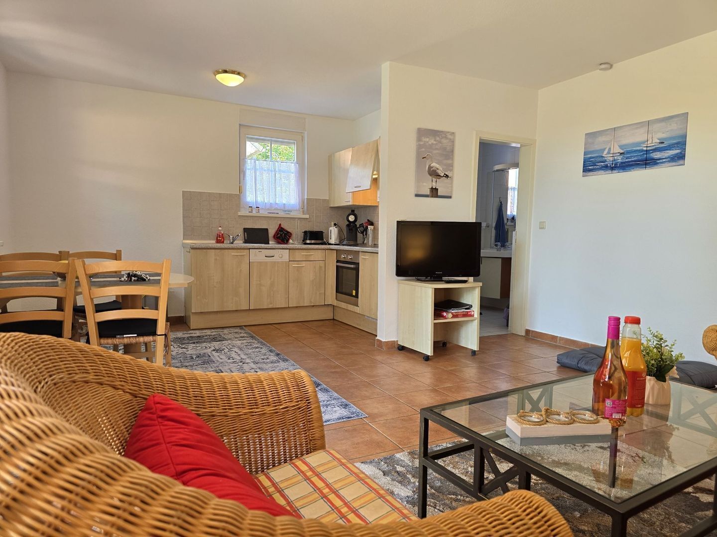 A compact living space with a dining area, kitchenette, and a television.