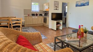 A compact living space with a dining area, kitchenette, and a television.