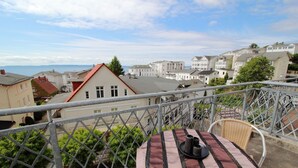 A balcony with a table and chairs, overlooking a residential area with houses and a view of the sea. - Alter Reichshof, App. 305 with balcony and sea view - Alter Reichshof, App. 305 - (Sassnitz auf Rügen)