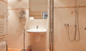 A bathroom with a sink, mirror, towel rack, shower, and a trash bin. - Villa Friede-Marie, App. Meeresidyll - with wonderful Baltic Sea view and balcony (Sassnitz auf Rügen)