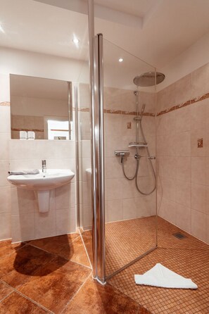 A modern bathroom with a glass-enclosed shower, a sink, and a mirror. - Villa Friede-Marie, App. Meeresidyll - with wonderful Baltic Sea view and balcony (Sassnitz auf Rügen)
