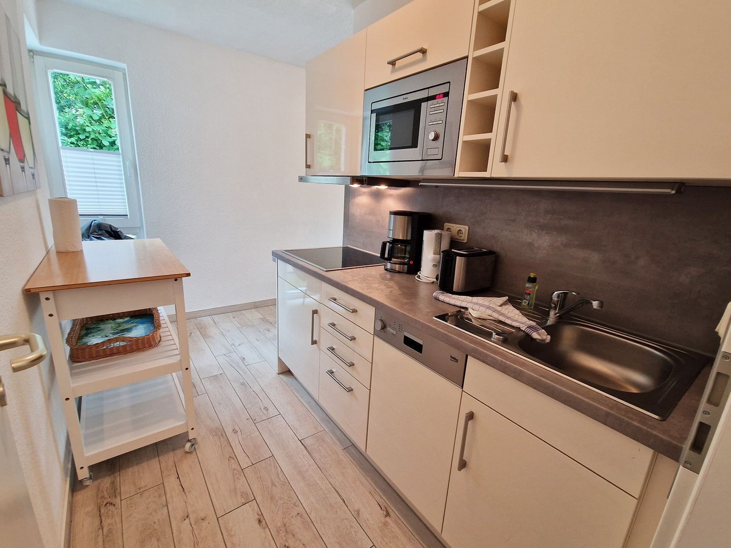 A compact kitchen with a microwave, coffee maker, and sink.
