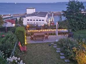 Ein Gebäude namens 'Altes Kühlhaus' mit einer Terrasse, die Sitzgelegenheiten im Freien und Lichterketten bietet.
